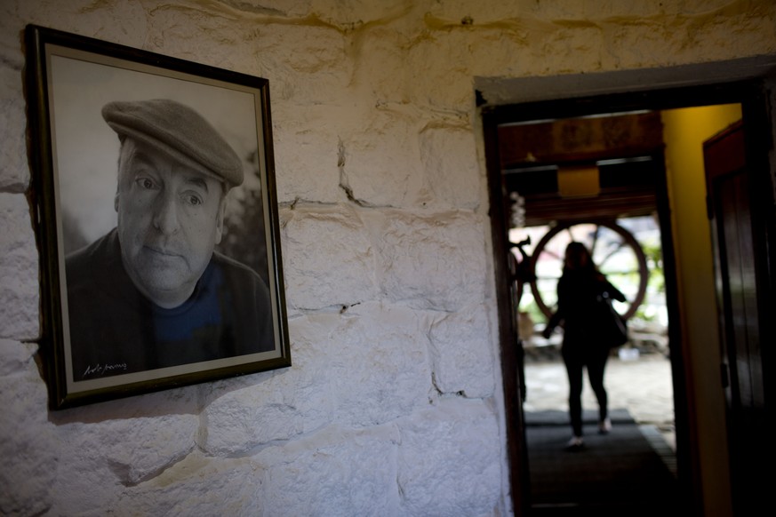 In this April 26, 2015 photo, a framed photo of Nobel Prize-winning poet Pablo Neruda hangs on a wall, as a tourist enters his favorite home in Isla Negra, Chile. In a statement released to The Associ ...