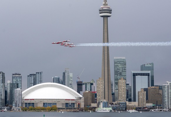 The Canadian Forces Snowbirds fly past the Toronto skyline as part of Operation Inspiration, their cross-country salute to Canadians helping fight the spread of COVID-19, on Sunday, May 10, 2020. (Fra ...