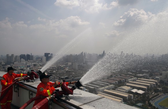 epa07335573 Thai officials spray water into the air from the top of a building aimed at lowering levels of harmful PM2.5 dust particles in Bangkok, Thailand, 01 February 2019. Fine particulate matter  ...
