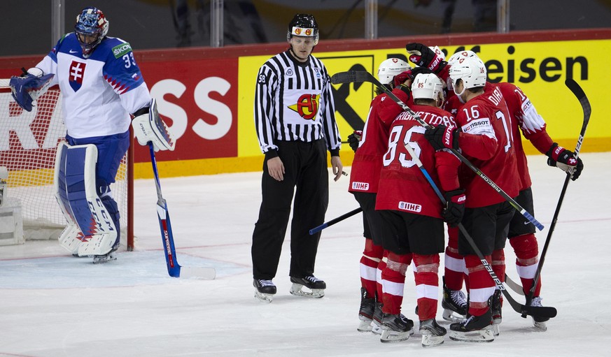 Switzerland&#039;s players celebrate their goal past Slovakia&#039;s goaltender Julius Hudacek, left, after scoring the 7:1, during the IIHF 2021 World Championship preliminary round game between Swit ...