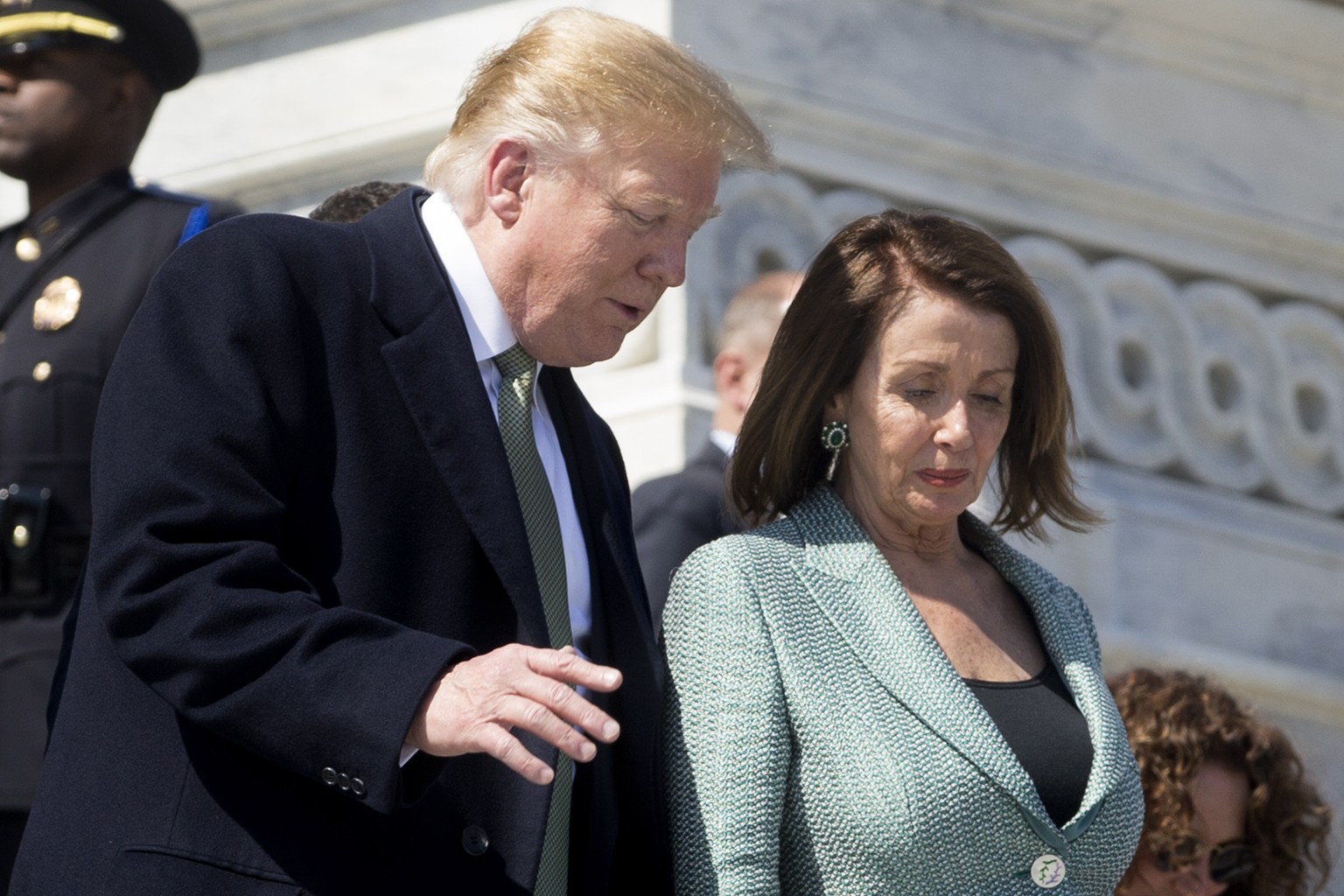 epa07437300 US President Donald J. Trump (L) and US Speaker of the House Nancy Pelosi (R) walk down the East Front House steps of the US Capitol following the Friends of Ireland luncheon in Washington ...