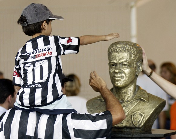 A young supporter of Brazilian team Botafogo touches the statue of Garrincha at Maracana stadium in Rio de Janeiro. A young supporter of Brazilian team Botafogo touches the statue of Mane Garrincha, t ...
