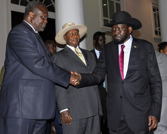 epa06929495 (FILE) - The President of South Sudan Salva Kiir (R) and the rebel leader Riek Machar (L) shake hands with Ugandan President Yoweri Museveni (C) between them after their meeting in Kampala ...