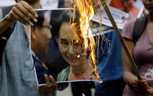 Activists of an ultra-leftist organization burn a poster featuring a photograph of Myanmar&#039;s State Counsellor Aung San Suu Kyi during a protest against the persecution of Rohingya Muslims near My ...