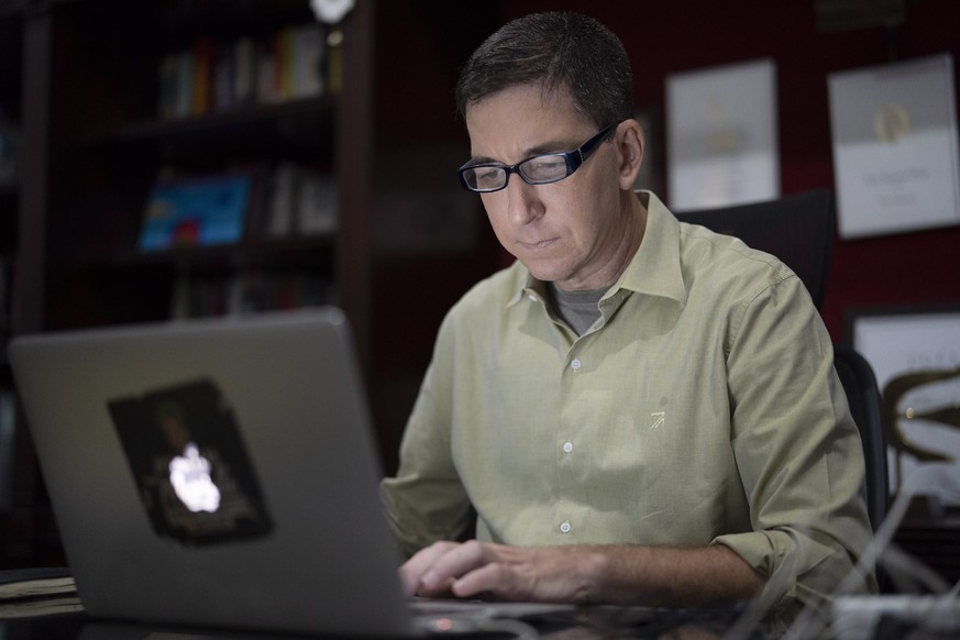 FILE - In this July 10, 2019 file photo, U.S. journalist Glenn Greenwald checks his news website at his home in Rio de Janeiro, Brazil. Brazilian prosecutors accused Greenwald on Tuesday, Jan. 21, 202 ...