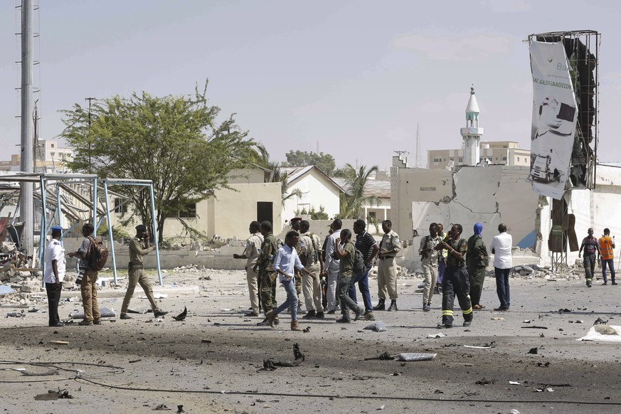 epa07244421 Somali security officers gather at the scene of twin explosions near the National Theater in Mogadishu, Somalia, 22 December 2018. A suicide car bomb reportedly exploded at a checkpoint ne ...