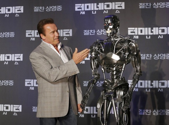 Actor Arnold Schwarzenegger stands with a model of a &quot;Terminator&quot; from the new film &quot;Terminator Genisys&quot; during a press conference at the Ritz Carlton hotel in Seoul, South Korea,  ...