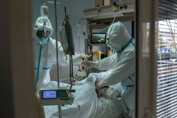 epa09023981 Medical staff assist a patient with coronavirus at the Intensive Care Unit (ICU) of the Cosaga Hospital in Ourense, province of Galicia, Spain, 19 February 2021. The number of Covid-19 inf ...
