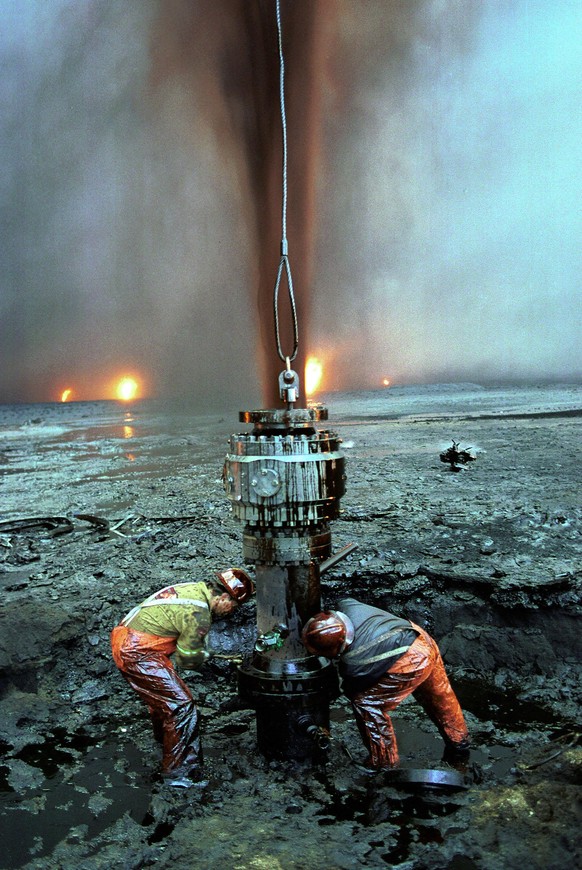 GREATER BURHAN OIL FIELD, KUWAIT - AUGUST 05: (.) Unidentified firefighters try to put out a leaking oil well August 5, 1991 at the Greater Burhan oil field in Kuwait. When the Gulf War ended in Febru ...