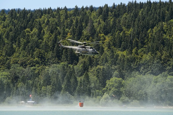 Ein Schweizer Superpuma schöpft Wasser aus dem Lac de Joux.