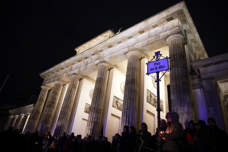 epa08231771 People attend a vigil after the Hanau terror attack at the Brandenburg Gate in Berlin, Germany, 20 February 2020. According to the police, the alleged perpetrator of a terror attack in Han ...
