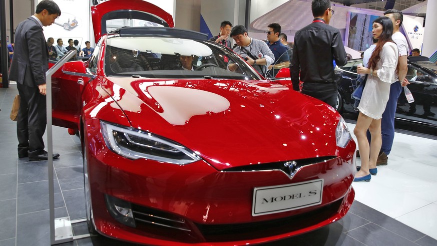 epa07295009 (FILE) - People look at a Tesla model S electric car on display at the Auto China 2016 motor show in Beijing, China, 26 April 2016 (reissued 18 January 2019). Tesla has issued a recall of  ...