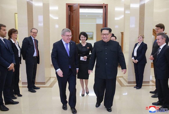 In this photo provided by the North Korean government on Saturday, March 31, 2018, North Korean leader Kim Jong Un, center right, walks with International Olympic Committee President Thomas Bach, cent ...