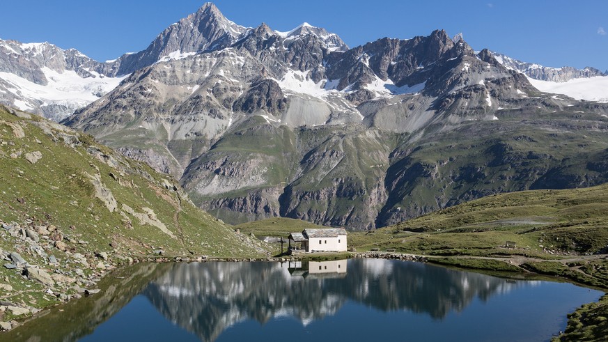 The chapel &quot;Maria zum Schnee&quot; (&quot;Mary of the Snows&quot;) and the group of mountains around Obergabelhorn mountain are reflected in Schwarzsee lake above Zermatt, Switzerland, pictured o ...