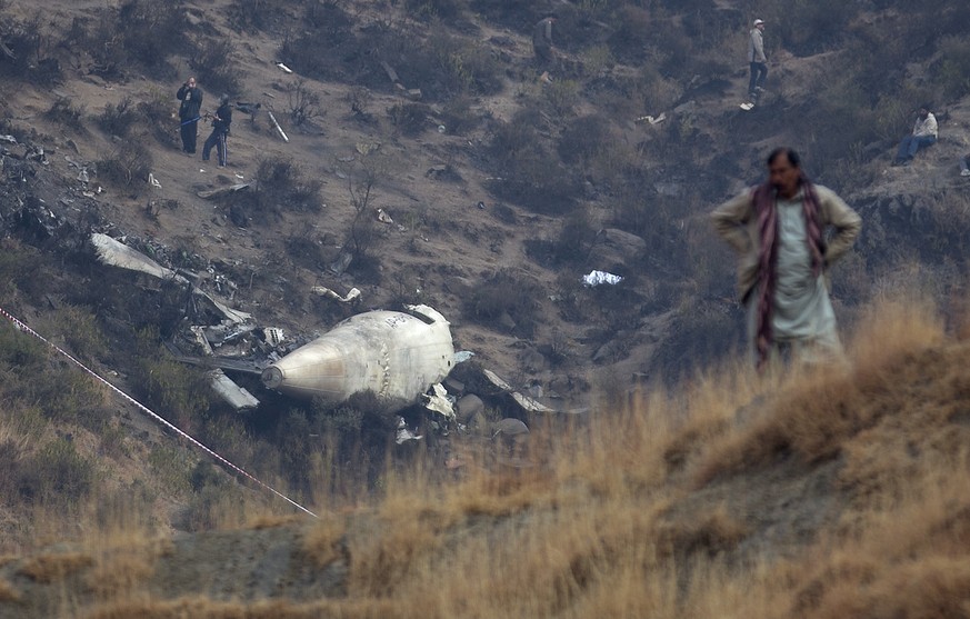 CORRECTS NAME OF THE VILLAGE - A Pakistan villager stands at the site of plane crash as investigation is in progress in Gug near Havelian, Pakistan, Thursday, Dec. 8, 2016. Pakistan&#039;s national ca ...