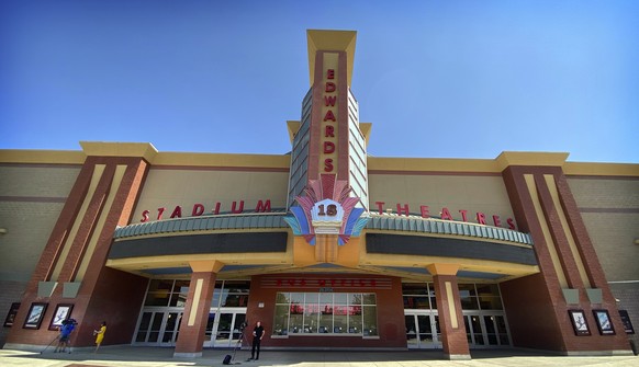 News crews report from in front of the Regal Edwards Corona Crossings movie theater, Tuesday, July 27, 2021, in Corona, Calif., following a shooting at the theater the night before that killed an 18-y ...