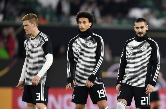 Germany&#039;s Marcel Halstenberg, left, Leroy Sane, center, and Ilkay Gundogan stand during warm up prior to a international friendly soccer match between Germany and Serbia at the Volkswagen Arena s ...