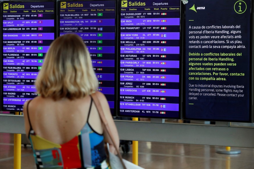 epa07806482 A woman checks her flight on a screen at El Prat airport in Barcelona, Spain, during the second day of strike held by Iberia&#039;s ground staff workers, 31 August 2019. According to the a ...