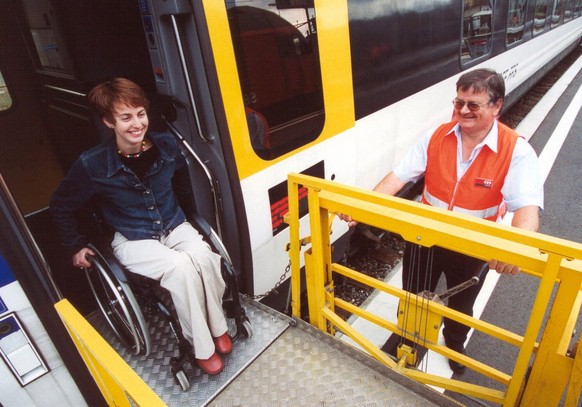 Ein SBB-Angestellter hilft einer gehbehinderten Frau den Austieg auf einem Bahnhof, undatierte Aufnahme. Am Freitag, 20 Juli 2001 stellten die SBB, der Verband oeffentlicher Verkehr (VOeV) und die Fac ...