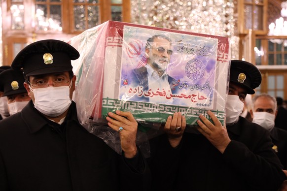 epa08850183 A handout picture provided by the Iranian defence ministry office shows the coffin of slain Iranian nuclear scientist Mohsen Fakhrizadeh is being carried inside the Shrine of Imam Reza, du ...