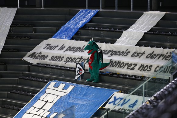 Fribourgs Maskottchen, der Drache, steht auf der leeren Zuschauertribuene, waehrend dem Eishockey Meisterschaftsspiel der National League zwischen dem HC Fribourg Gotteron und den ZSC Lions, am Sonnta ...