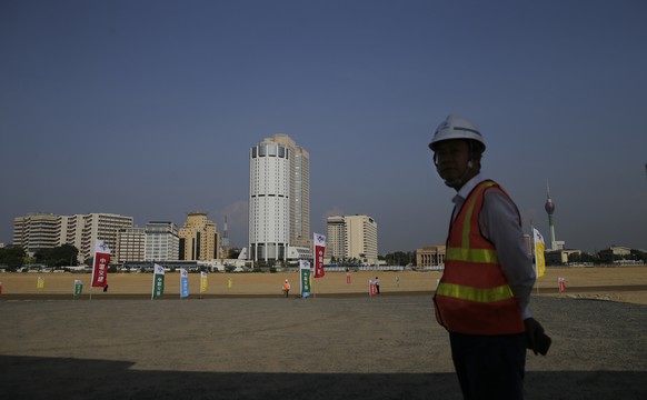 FILE - In this Jan. 2, 2018 file photo, a Chinese construction worker stands on land that was reclaimed from the Indian Ocean for the Colombo Port City project, initiated as part of China&#039;s ambit ...
