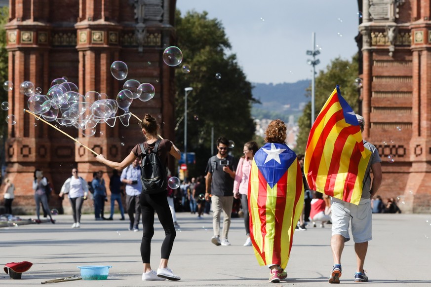 epa06256737 A couple holds the &#039;Estelada&#039;, Catalonian Independence movement flag, as they walk near the Ciutadella park which surrounds Catalonia&#039;s regional assembly in Barcelona, Spain ...