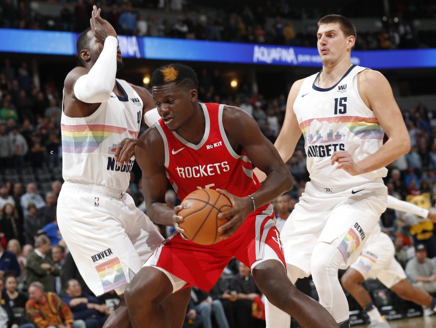 Houston Rockets center Clint Capela, center, goes up for a basket between Denver Nuggets forward Paul Millsap, left, and center Nikola Jokic in the first half of an NBA basketball game Tuesday, Nov. 1 ...