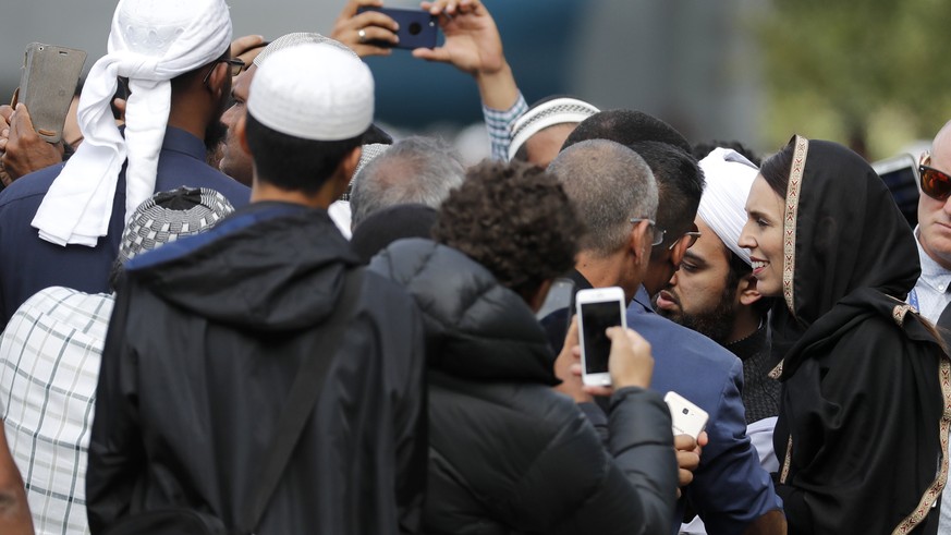 New Zealand Prime Minister Jacinda Ardern, right, meets muslim men following Friday prayers at Hagley Park in Christchurch, New Zealand, Friday, March 22, 2019. People across New Zealand are observing ...