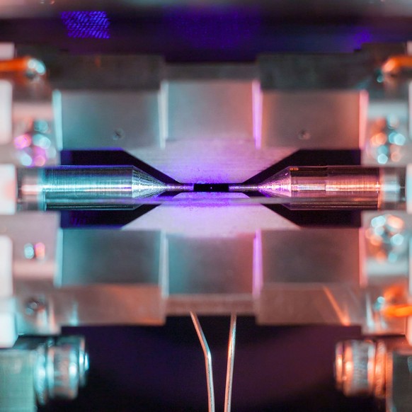 An der Universität Oxford gelang David Nadlinger diese Langzeitbelichtungs-Aufnahme. Von zwei elektromagnetischen Feldern in Schach gehalten, reflektiert das Atom einen blau-violetten Laser.