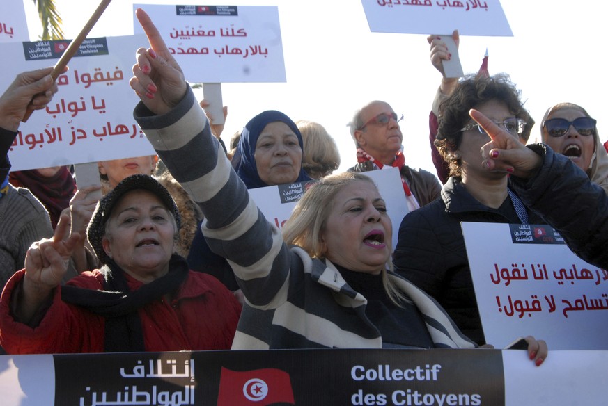 People demonstrate outside the Tunisian parliament, in Tunis, Saturday, Dec. 24, 2016. About 200 people have protested in the Tunisian capital against the return of Tunisian jihadis who have fought ab ...