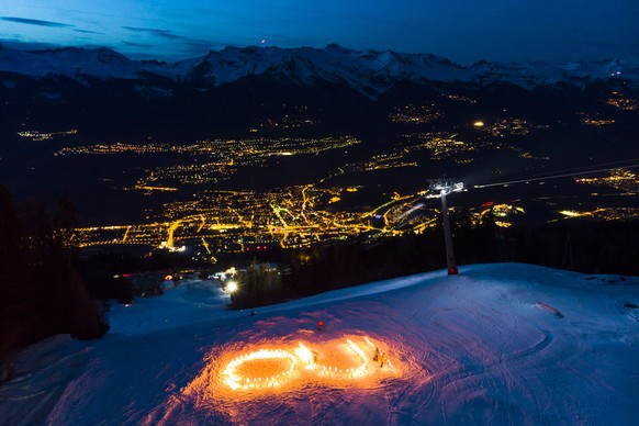 epa06669915 Torches are lit on the ski slope La Piste de l&#039;Ours forming the word &quot;Oui&quot; (yes in French), during an event in support of the 2026 Winter Olympic Games candidature of the ci ...