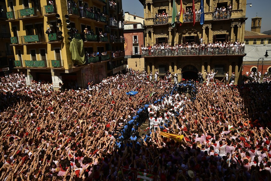 Revellers celebrate the official opening of the 2019 San Fermin fiestas in Pamplona, Spain, Saturday July 6, 2019. The blast of a traditional firework opened Saturday nine days of uninterrupted partyi ...