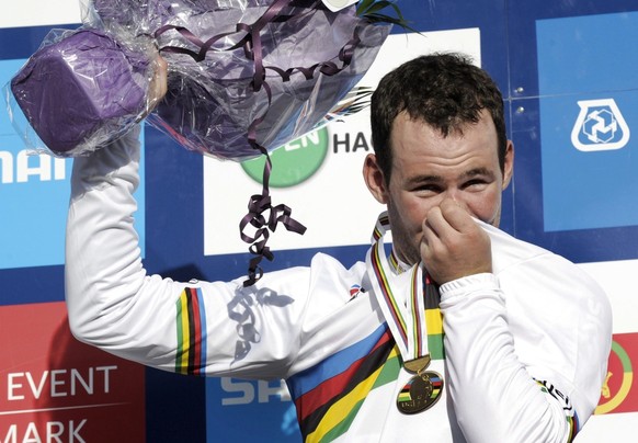 epa02935007 Mark Cavendish from Great Britain (C) waves on the podium after winning the gold medal in the Men&#039;s Elite race at the UCI Cycling Road World Championships on September 25, 2011 in Rud ...