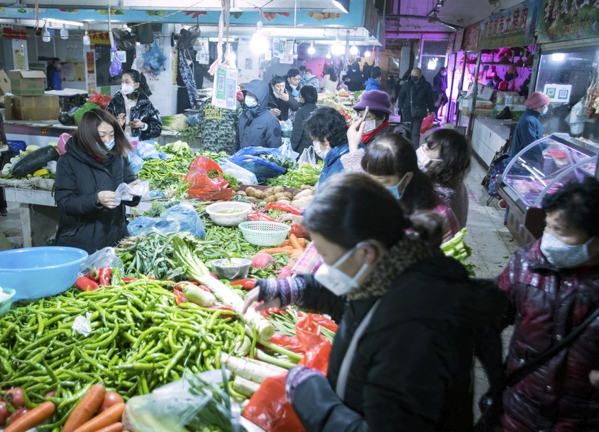 In this photo released by China&#039;s Xinhua News Agency, people shop for vegetables at a market in Wuhan in central China&#039;s Hubei Province, early Thursday, Jan. 23, 2020. China closed off a cit ...