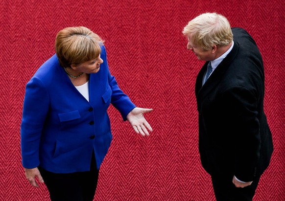 epa07784607 German Chancellor Angela Merkel (L) talks to British Prime Minister Boris Johnson after they observed military honors at the Chancellery in Berlin, Germany, 21 August 2019. Prior to the G7 ...