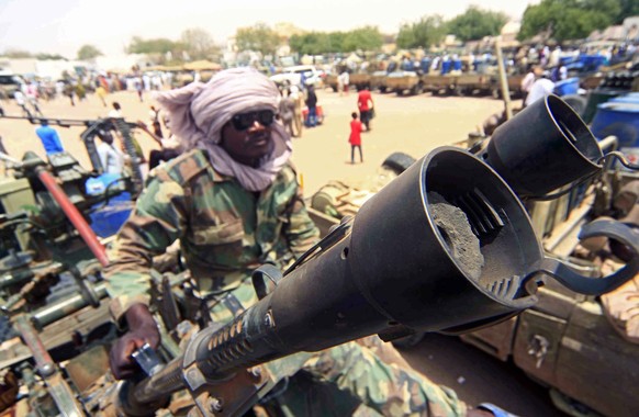 epa08636963 (FILE) - A militia members sits beside military equipment allegedly seized during a battle in the contested area of south Darfur, Nyala, Sudan, 04 May 2015 (reissued 31 August 2020). The S ...