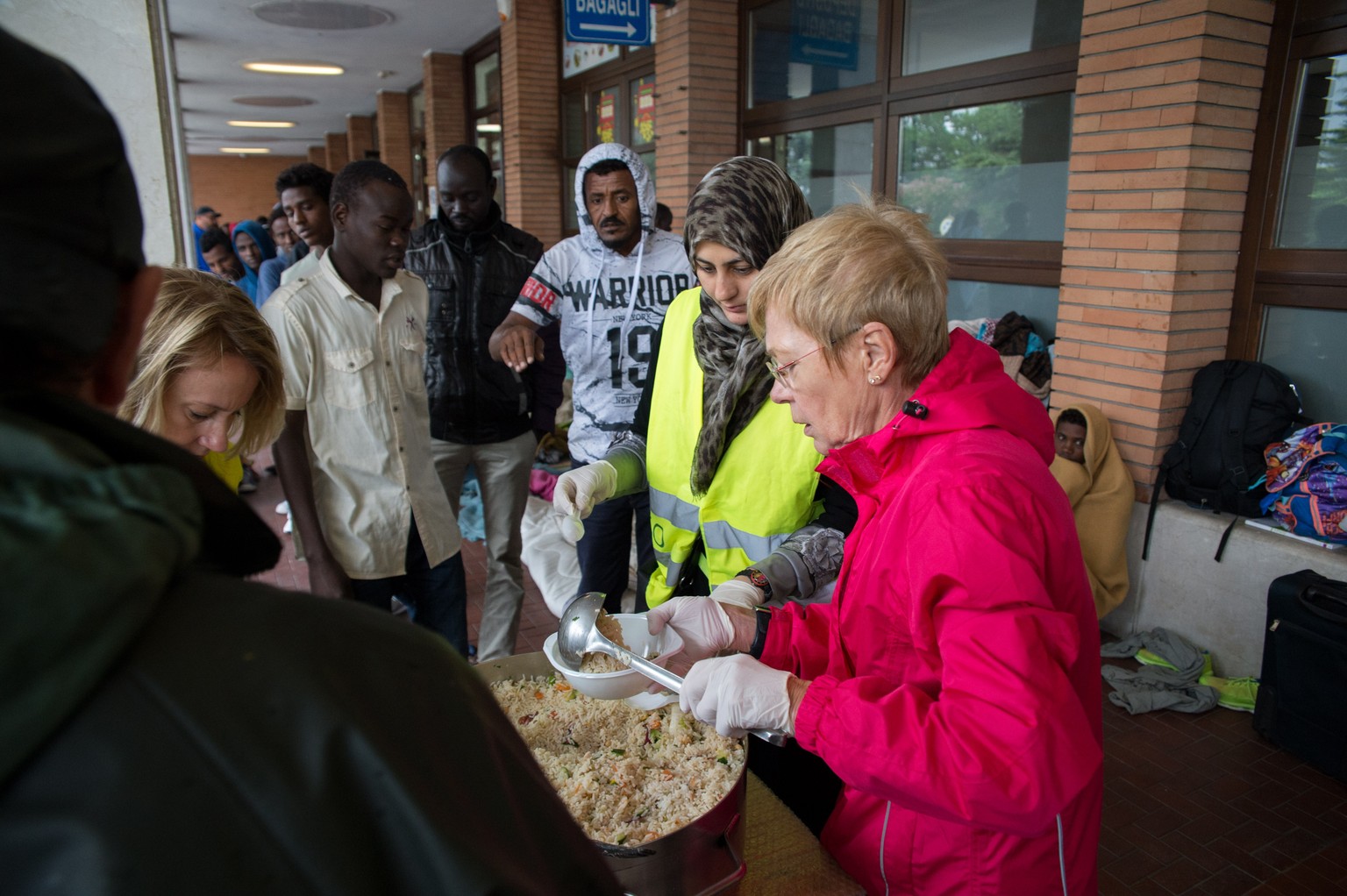 Fluechtlinge erhalten eine Mahlzeit von Freiwilligen der Tessiner Hilfsgruppe Associazione Firdaus, am Freitag, 5. August 2016, am Bahnhof in Como, Italien. Derzeit befinden sich in Como viele Fluecht ...