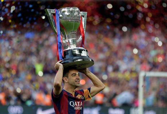 FC Barcelona&#039;s Xavi Hernandez holds up the trophy after winning the Spanish League title, at the end of their Spanish La Liga last round soccer match against Deportivo Coruna at the Camp Nou stad ...