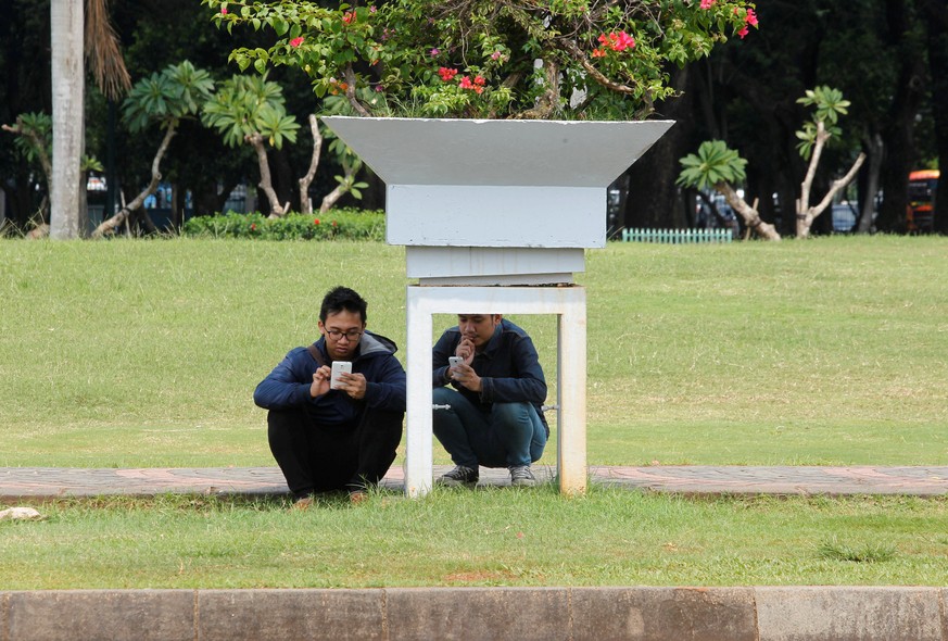 People play the mobile phone game Pokemon GO in a park in Central Jakarta, Indonesia July 21, 2016. REUTERS/Iqro Rinaldi