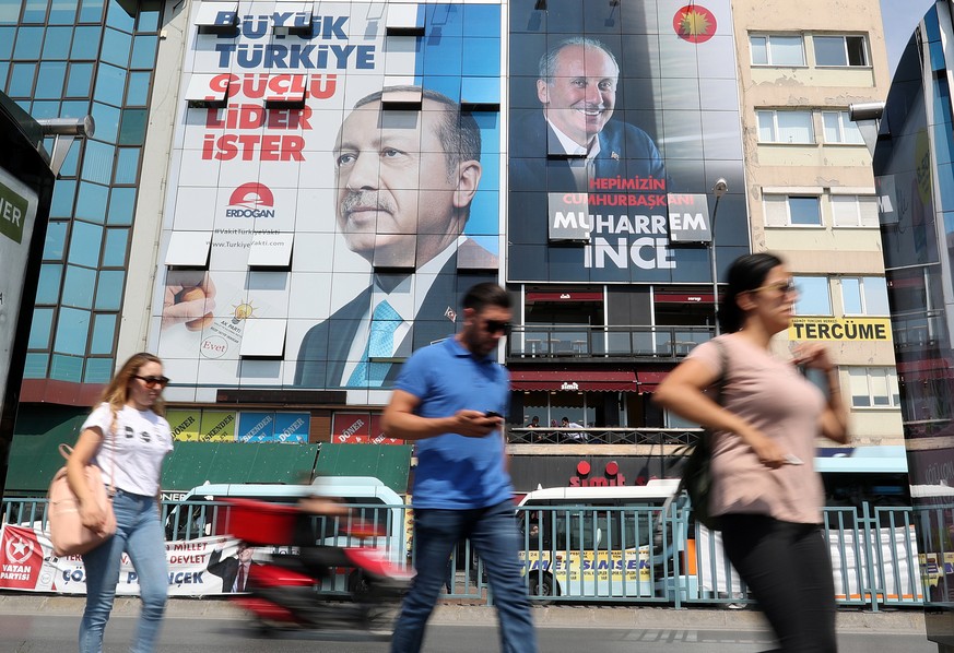 epa06788906 People walk under a huge picture of Turkish President Recep Tayyip Erdogan (L) and Muharrem Ince (R), Presidential candidate of Turkey&#039;s main opposition Republican People&#039;s Party ...