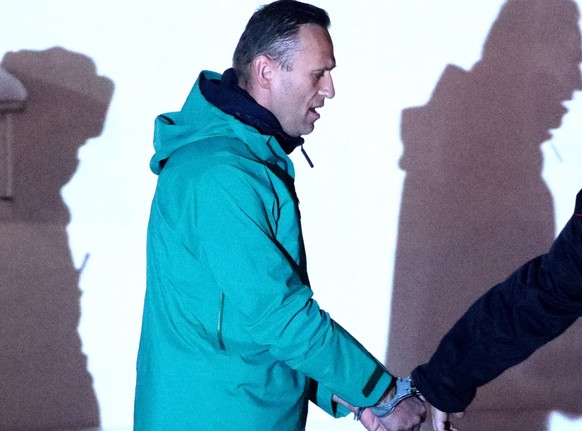 Alexej Nawalny, Oppositionspolitiker und Kremlkritiker, wird von einem Polizeibeamten vor der 2. Abteilung der Direktion des russischen Innenministeriums von Chimki eskortiert. Foto: Sergei Bobylev/TA ...