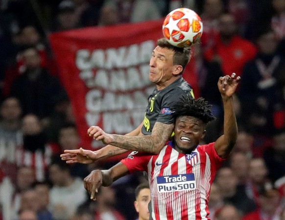 epa07384027 Atletico de Madrid&#039;s midfielder Thomas Partey (R) vies for the ball against Juventus&#039; forward Mario Mandzukic (L) during the UEFA Champions League round of 16 first leg match bet ...