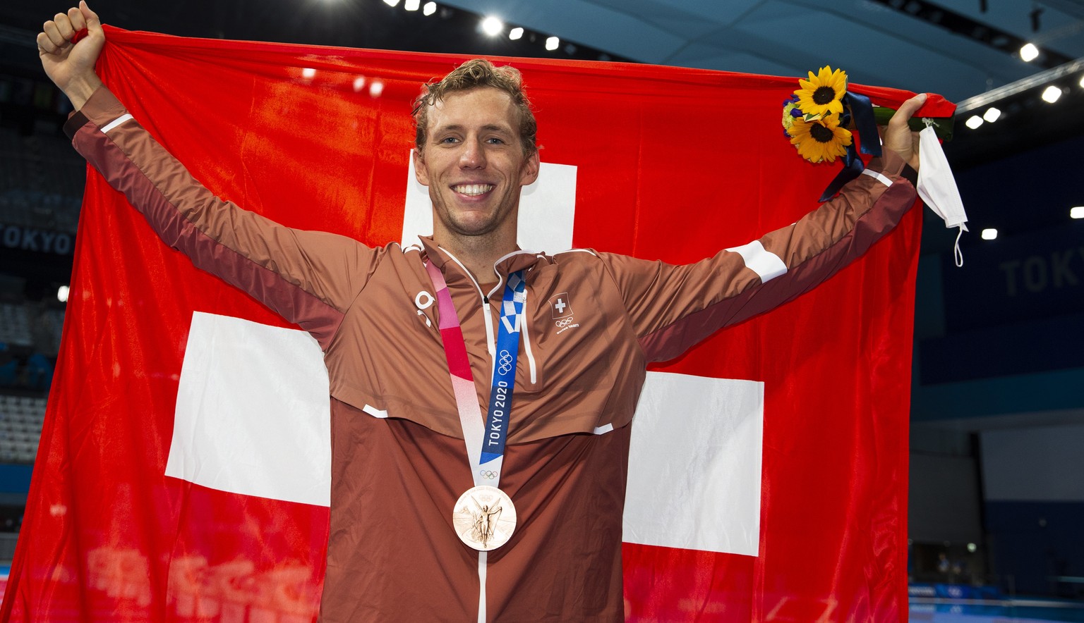 epa09378091 Jeremy Desplanches of Switzerland poses with his Bronze medal and a Swiss flag after finishing third in the men&#039;s 200m Individual Medley Final during the Swimming events of the Tokyo  ...