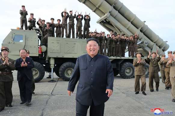 This Saturday, Aug. 24, 2019, photo provided Sunday, Aug. 25, by the North Korean government, shows North Korean leader Kim Jong Un, center, smiles after the test firing of an unspecified missile at a ...