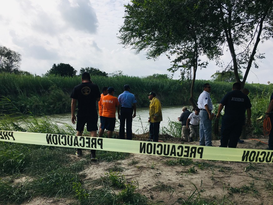 Authorities stand behind yellow warning tape along the Rio Grande bank where the bodies of Salvadoran migrant Oscar Alberto Martínez Ramírez and his nearly 2-year-old daughter Valeria were found, in M ...