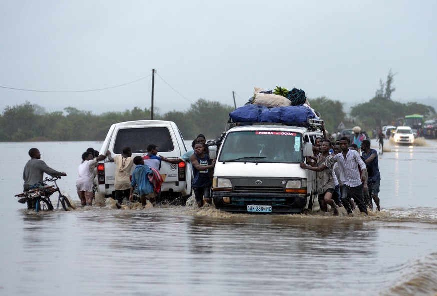 epa07538170 People push vehicles on a flooded road after the passage of Cyclone Kenneth in Metuge, Cabo Delgado, northern Mozambique, 28 April 2019 (issued 30 April 2019). The passage of Cyclone Kenne ...