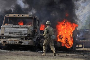 US-Soldaten inspizieren die zerstörten Lastwagen.