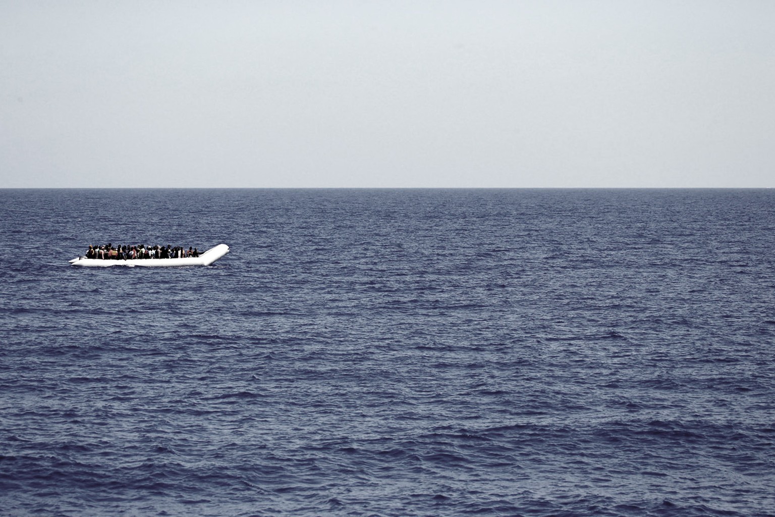 A rubber boat loaded of migrants is seen during a search and rescue mission in the mediterranean sea off the Libyan coasts, Italy, Tuesday, June 23, 2015. Hundreds of migrants were rescued on Tuesday  ...