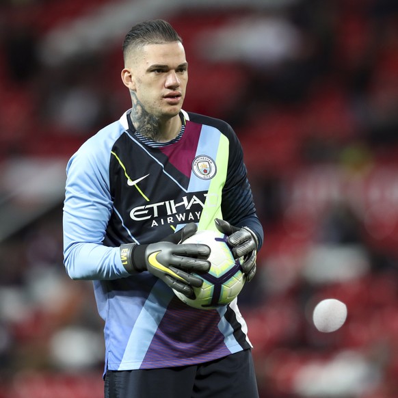 Manchester City goalkeeper Ederson holds a football during warmup before the English Premier League soccer match between Manchester United and Manchester City at Old Trafford Stadium in Manchester, En ...